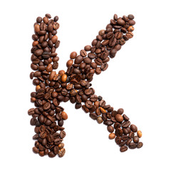 Letter K of the English alphabet of freshly roasted cocoa beans on a white isolated background.