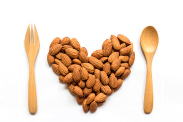 Almonds heart shape pattern with wood fork and spoon isolated on white background with blank.Love valentine's day concept.