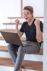 happy young man looking at his laptop screen