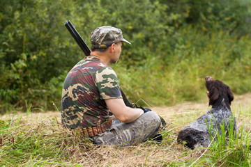 hunter and his dog resting on the mown grass