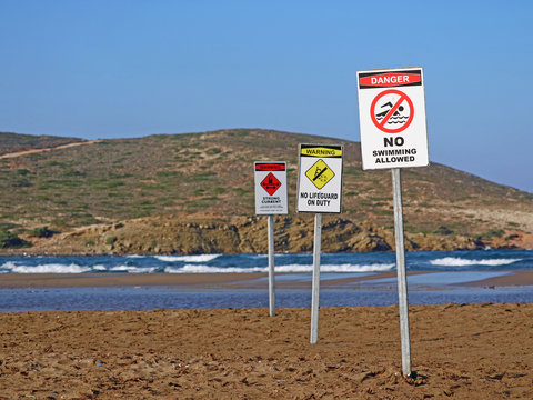 Three warning signs on prasonisi beach, rhodes, greece, no swimming because of big waves