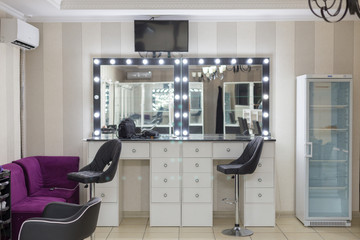Decorative cosmetics and dressing table near the mirror in the dressing room