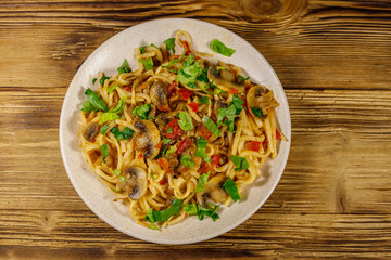 Pasta with mushrooms and tomato sauce on wooden table. Top view