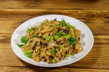 Tasty risotto with mushrooms on wooden table