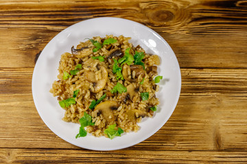Tasty risotto with mushrooms on wooden table. Top view