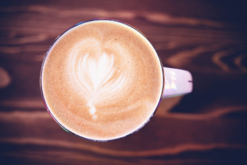 Cappuccino with a pattern on the foam, shot from above on a wooden table