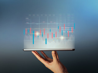 Stock exchange market concept, hand trader holding on digital tablet with graphs analysis candle line.
