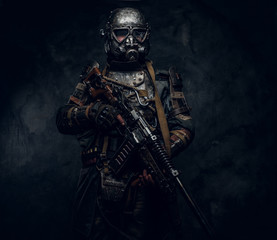 Naklejka premium Man is wearing great costume of futuristic knight in gas mask and is holding weapon.