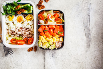 Lunch boxes with balanced healthy food, top view. Rice with fish, cheese, eggs and vegetables in food containers.
