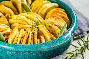 Baked white sweet potato casserole with herbs in blue dish. Healthy vegan food concept.