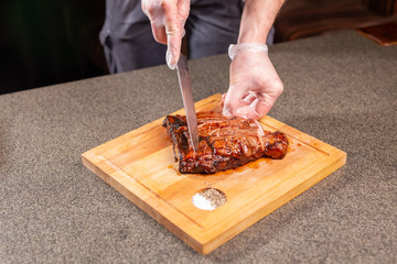 food, delicious and craft concept - Man cutting horse steak