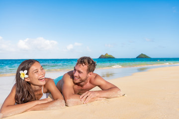 Happy interracial couple beach vacation summer fun relaxing laughing together. Hawaii travel...