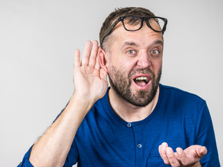 Man eavesdropping with hand close to ear