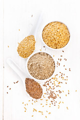 Fototapeta na wymiar Flour linen in bowl with seeds on light board top