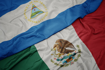 waving colorful flag of mexico and national flag of nicaragua. macro