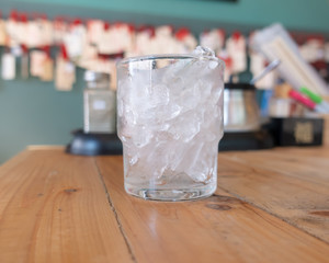 Ice in glass on the table background,