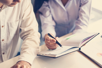 Young businessman discussing a document with co-worker at the working space. Business, startup, planning, management and people concept.