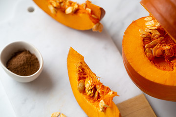 pumpkins with cinnamon sticks on marble backgrund