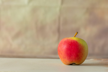 Red apple on the table with blurred wall vintage background,