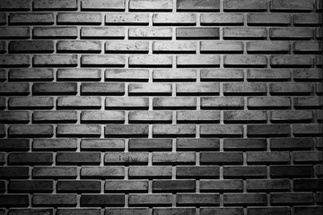 Abstract background from black brick pattern wall with light and shadow. Dramatic backdrop.