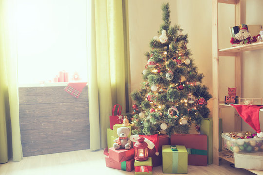 Merry Christmas! Beautiful holdiay decorated room with Christmas tree with presents under it over window