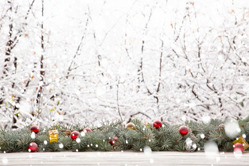 Garland of pine or fir tree branches and Christmas decorations against the background of falling...