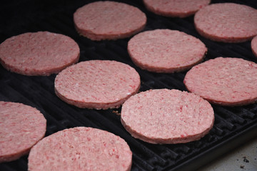Close up of raw hamburgers on a grill