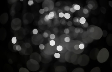 The abstract background of white bokeh on a black background. © wanchai