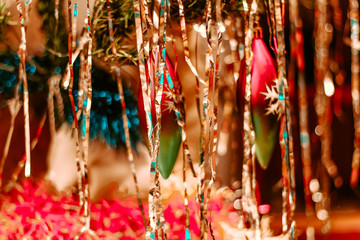 Bright sparkling Pattern of christmas tinsel and new year decorations on a tree. Shining tinsel decoration at home. 