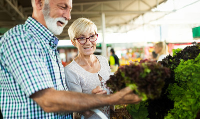 Portrait of beautiful elderly couple in market buing food