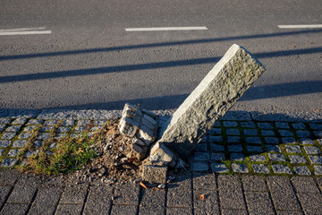askew granite pillar on walkway after traffic accident