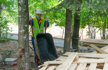 worker in protective clothing throws garbage from a cart to a landfill