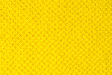 The tail is made of yellow knitted fabric texture. knitting texture close up Photo. orange, yellow knitted background. the texture of the warm fabric. colorful bright wool