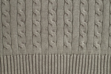The tail is made of beige knitted fabric texture. Machine knitting texture close up Photo. Beige grey knitted background. the texture of the warm fabric