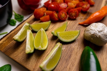 Close up of a cutting board with  a selection of healthy vegetables and fruit on a wooden cutting board