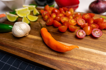 Close up of a cutting board with  a selection of healthy vegetables and fruit on a wooden cutting board