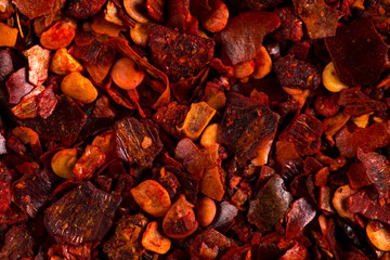 Crushed dried chili pepper red background, close-up macro. Concept, copy space.
