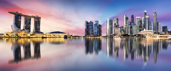 De skyline van Singapore bij zonsopgang - panorama met reflectie