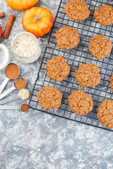 Fototapeta na wymiar Spicy pumpkin and oatmeal cookies on cooling rack, vertical, top view, copy space