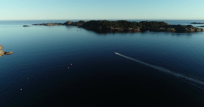 Aerial footage of speed booat crossing peaceful blue water near bautiful island. 