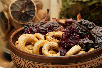 fresh bread, bagels, dried fruits, seeds, salt, jar and wheat on the wooden - still life and healthy eating concept