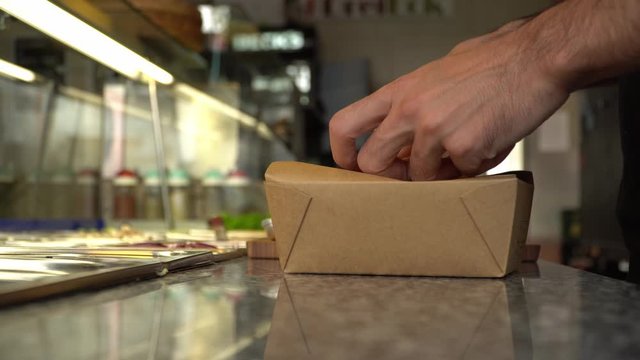 Closing a paper box for food delivery