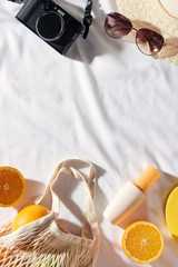 Flat lay Picnic, with glasses, an orange bag, sun cream and a straw hat with space. Summer mood