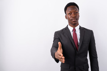 Young handsome African businessman wearing suit against white ba