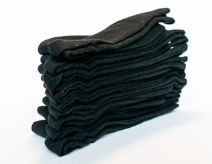 A stack of black socks on white background
