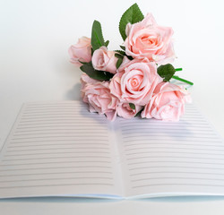 Pink roses on open note book
