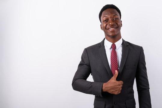 Young handsome African businessman wearing suit against white ba