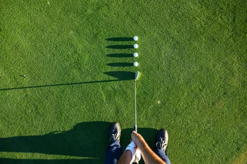Fototapete Rund Golf balls in line while putting for accuracy © karrastock