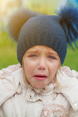 Sad crying offended girl cold autumn outdoor. Concept of upset child