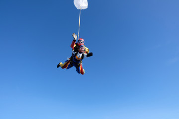 Obraz na płótnie Canvas Skydiving. Tandem jump. A man and a woman are in the sky.